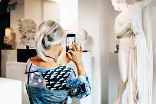 Visitor in the museum, taking a picture of a scultpture, picture: feinesbild